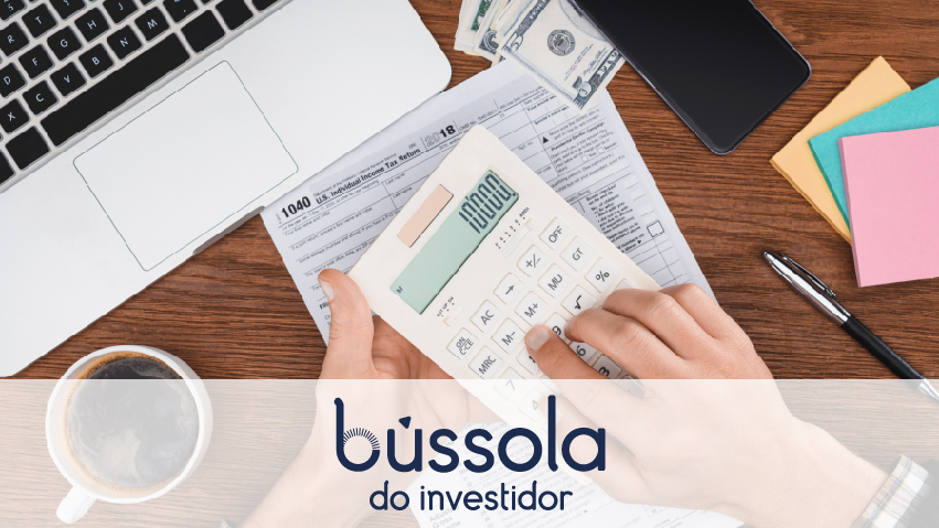 Mão na calculadora fazendo o cálculo do preço médio de ações