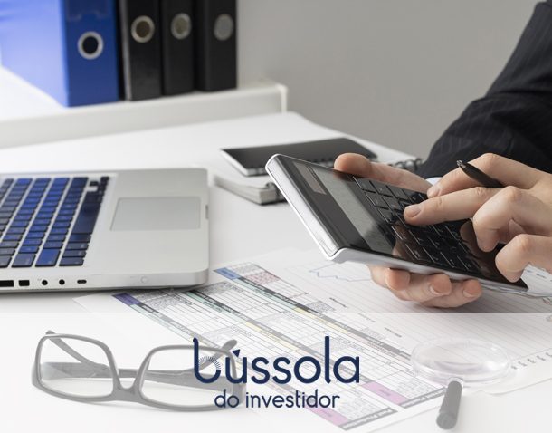 Mãos de um homem na calculadora pensando em como começar a investir