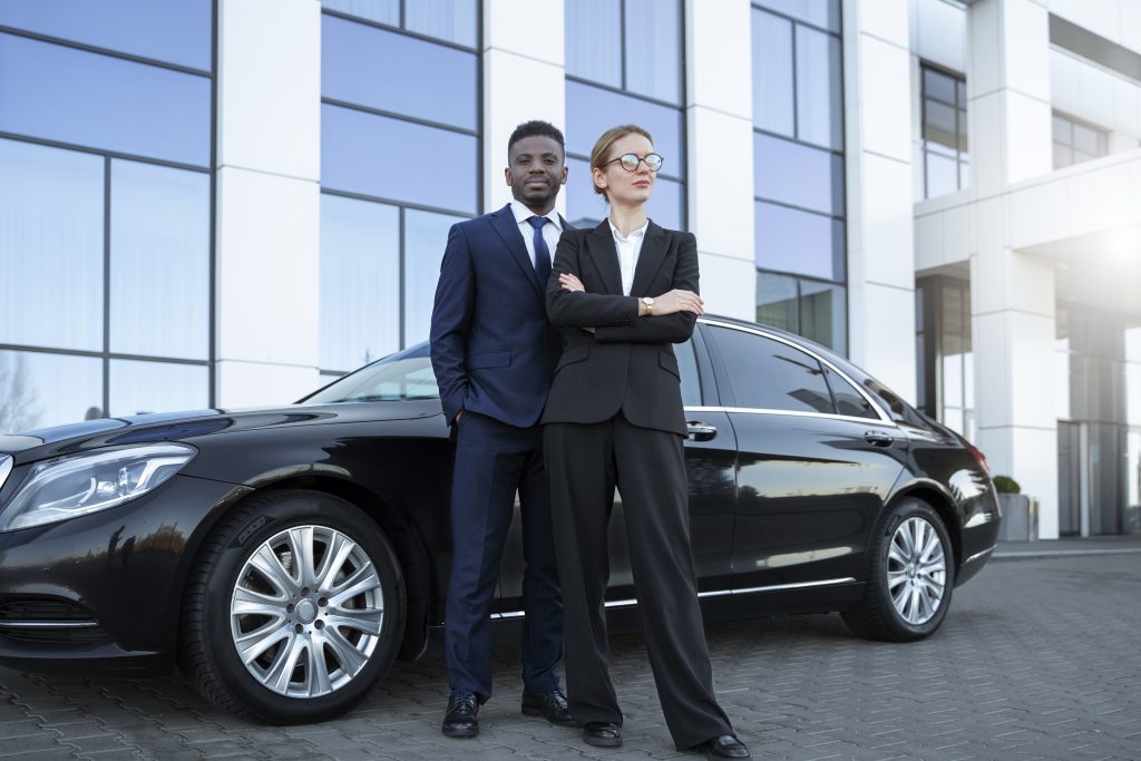 Homem e mulher na frente de um carro preto adquirido com fundos Capex